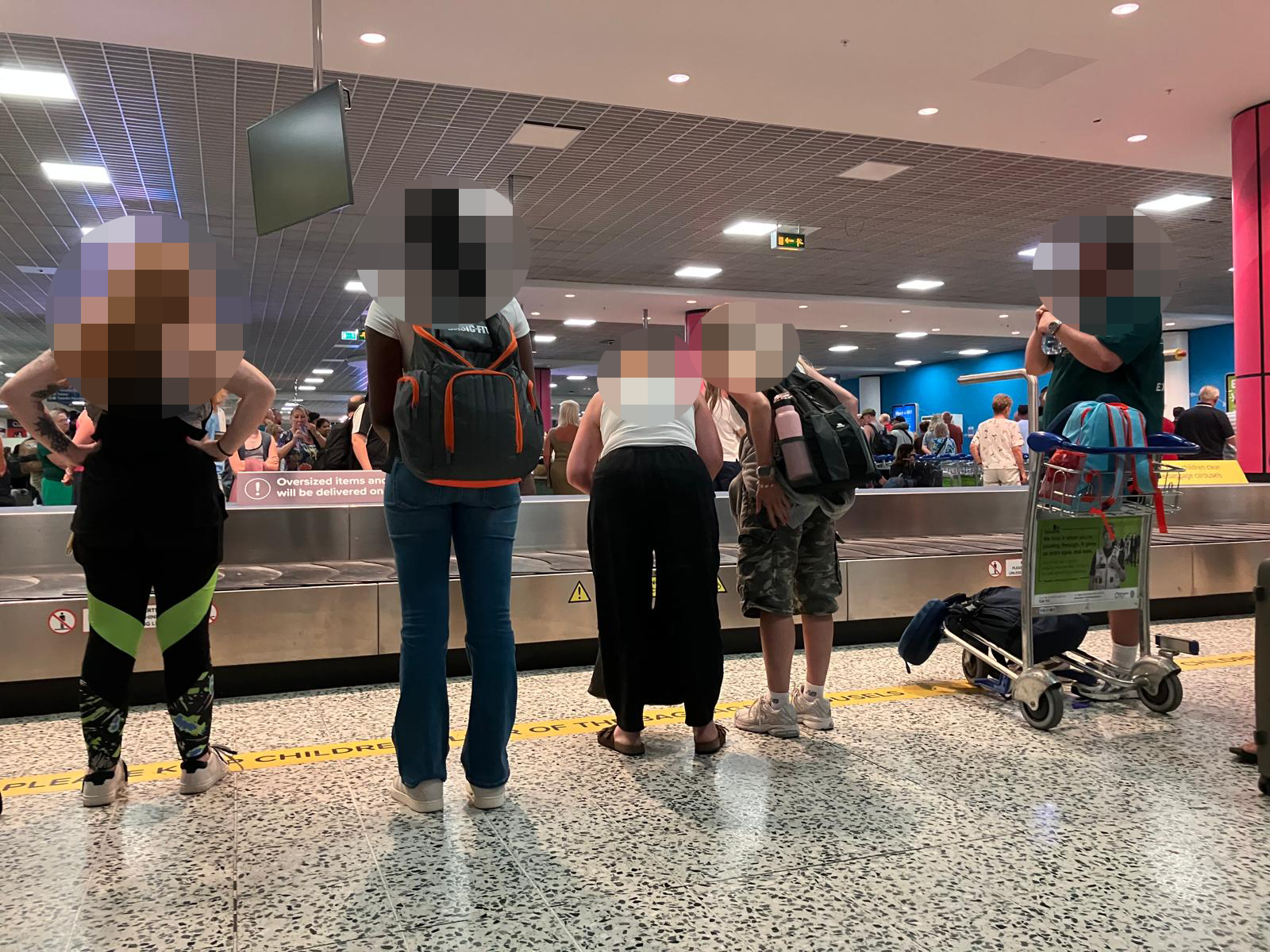 Passengers wait for their baggage at an airport conveyor belt. Passengers wait for their baggage at an airport conveyor belt.